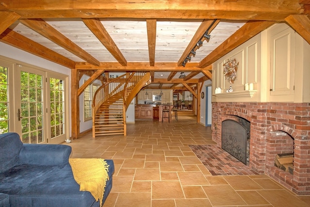 tiled living room with beam ceiling, a fireplace, and rail lighting