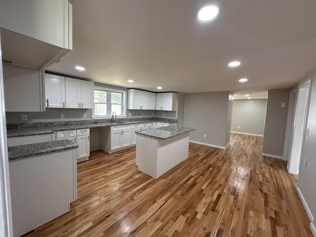 250 Gresham St, Springfield, MA 01119 - kitchen featuring light wood-type flooring, white cabinets, recessed lighting, a center island, and light stone countertops
