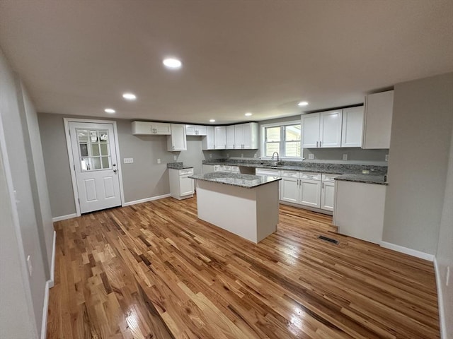 250 Gresham St, Springfield, MA 01119 - kitchen with light wood-style floors, white cabinets, recessed lighting, a center island, and stone countertops