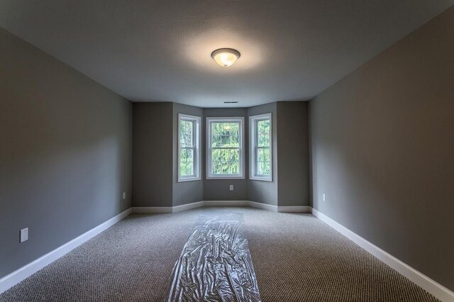 empty room with carpet flooring and baseboards