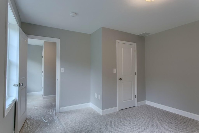 spare room featuring baseboards and carpet flooring