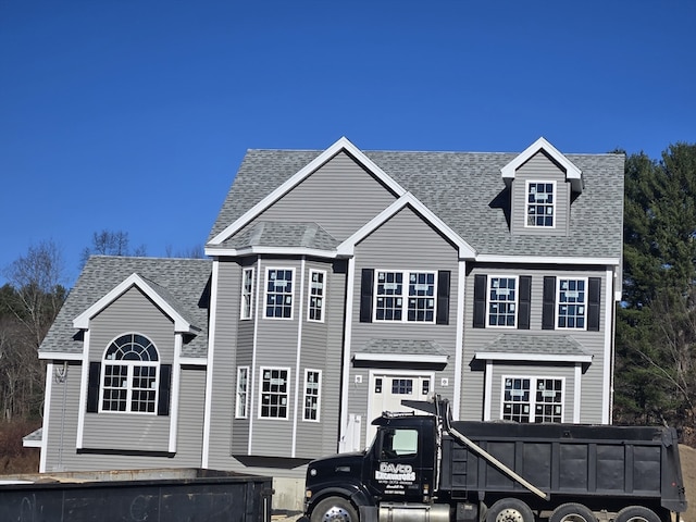 view of front of home with a garage and roof with shingles