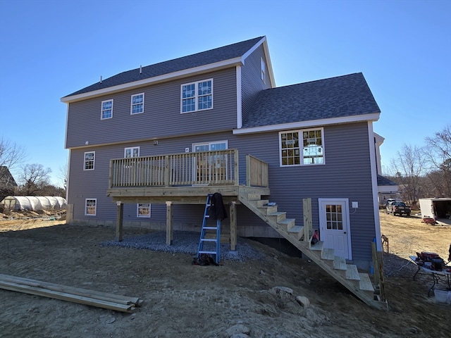 back of property with roof with shingles, a wooden deck, and stairs