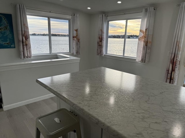 kitchen with hardwood / wood-style floors and a water view