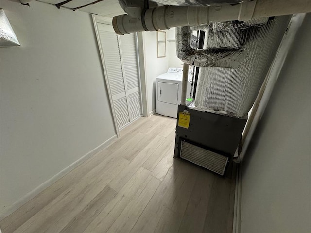 basement featuring light hardwood / wood-style flooring and washer / dryer