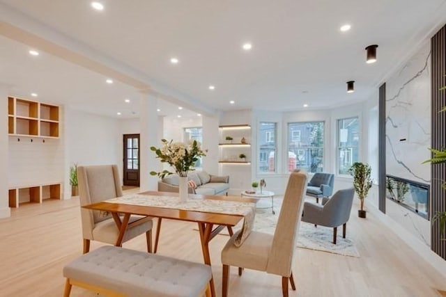 dining area featuring a high end fireplace, recessed lighting, and light wood-style flooring