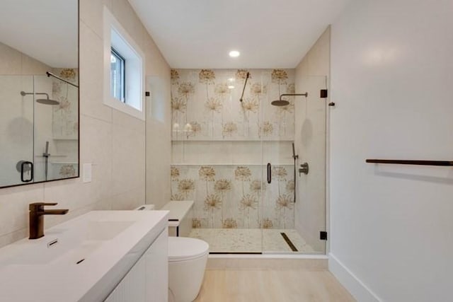 full bath with tile walls, a shower stall, toilet, and wood finished floors