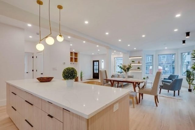 kitchen featuring light wood-style flooring, a large island, modern cabinets, open floor plan, and light brown cabinetry