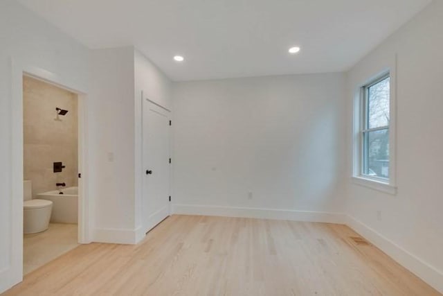 unfurnished room featuring light wood-style flooring, baseboards, and recessed lighting