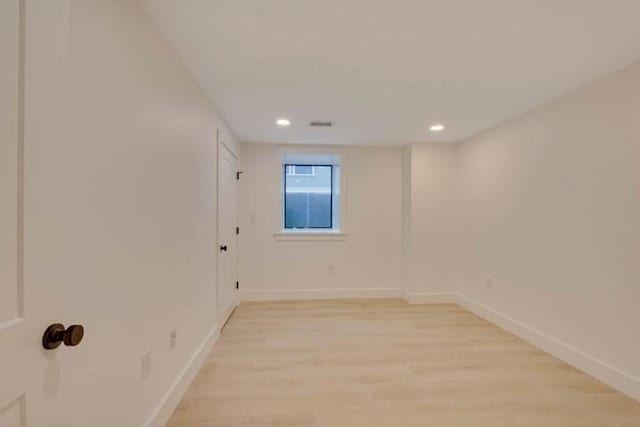 unfurnished room featuring light wood finished floors, baseboards, and recessed lighting