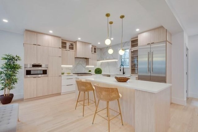 kitchen featuring modern cabinets, appliances with stainless steel finishes, and light brown cabinetry