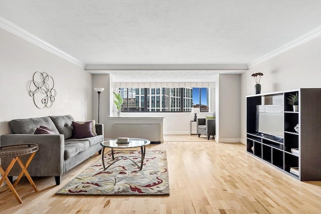 living area featuring baseboards, ornamental molding, and wood finished floors