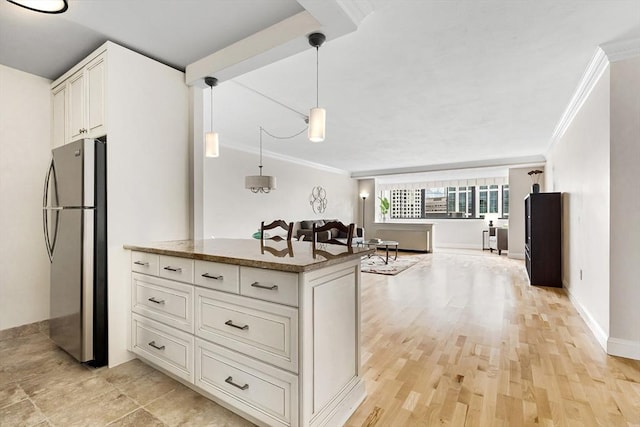 kitchen with baseboards, light wood-style flooring, open floor plan, freestanding refrigerator, and crown molding