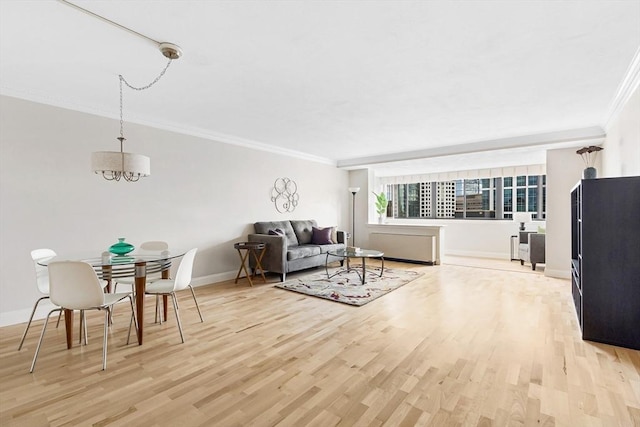 living area with light wood-type flooring, baseboards, a chandelier, and crown molding