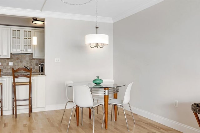 dining area with light wood-type flooring, baseboards, and ornamental molding