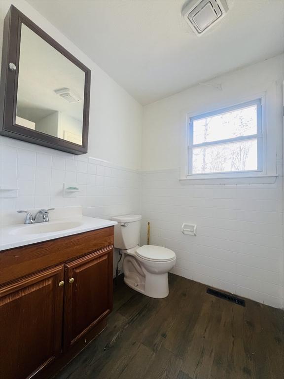 bathroom with hardwood / wood-style floors, vanity, and toilet