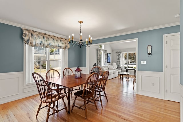 dining area with ornamental molding, a wealth of natural light, and light hardwood / wood-style flooring