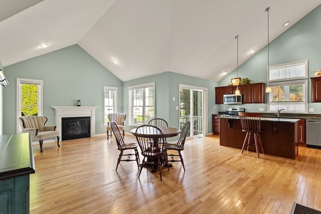 dining space featuring light hardwood / wood-style flooring and high vaulted ceiling