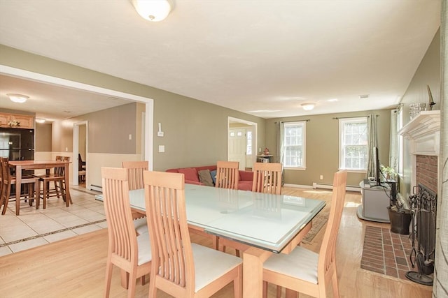 619 Pond St, Weymouth, MA 02190 - dining area featuring a fireplace, baseboard heating, and light wood-style flooring