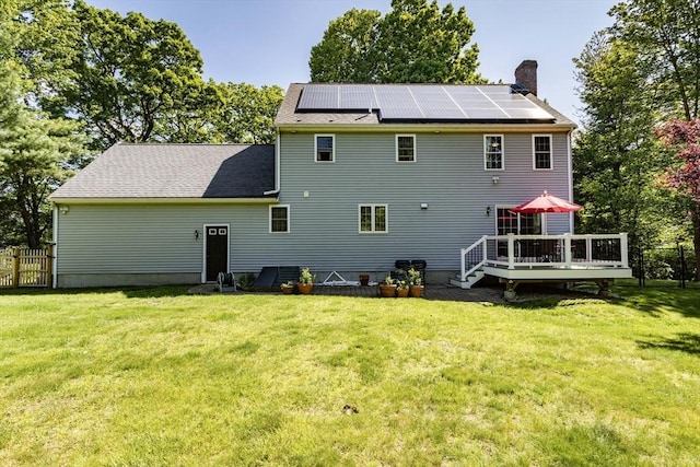 619 Pond St, Weymouth, MA 02190 - rear view of house with a deck, a chimney, and roof mounted solar panels