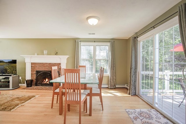 619 Pond St, Weymouth, MA 02190 - dining area with plenty of natural light, light wood-style floors, a fireplace, and baseboards
