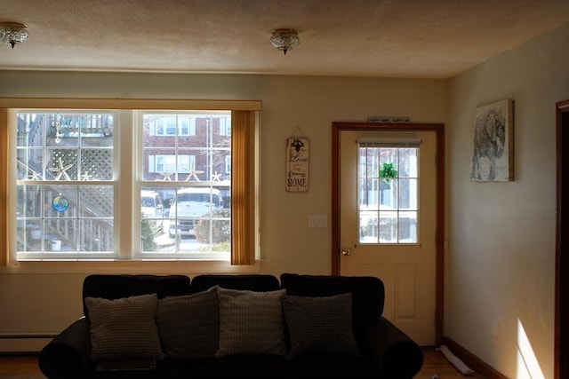 676 Bedford St, Abington, MA 02351 - living room with baseboards, a baseboard radiator, and a textured ceiling