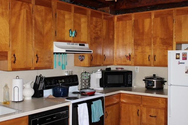676 Bedford St, Abington, MA 02351 - kitchen with under cabinet range hood, brown cabinets, black appliances, and light countertops