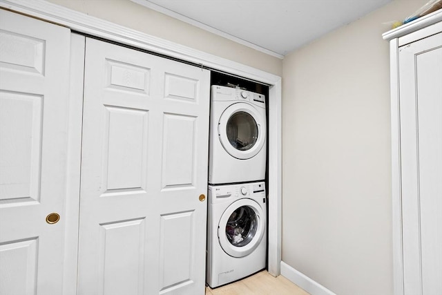 washroom with stacked washer / dryer and light wood-type flooring