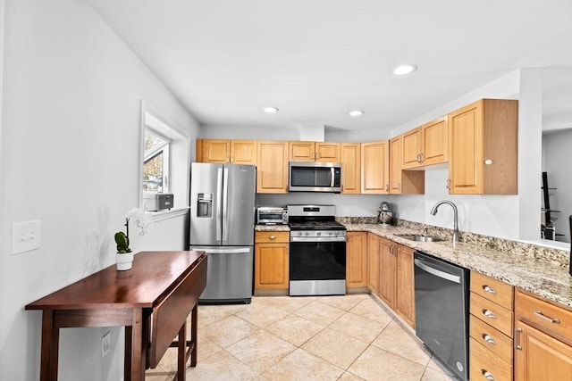 kitchen with sink, appliances with stainless steel finishes, light stone counters, light tile patterned flooring, and light brown cabinetry