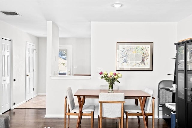 dining space with hardwood / wood-style flooring and a healthy amount of sunlight