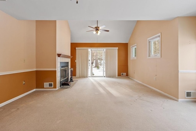 unfurnished living room featuring light colored carpet, baseboards, visible vents, and a tiled fireplace