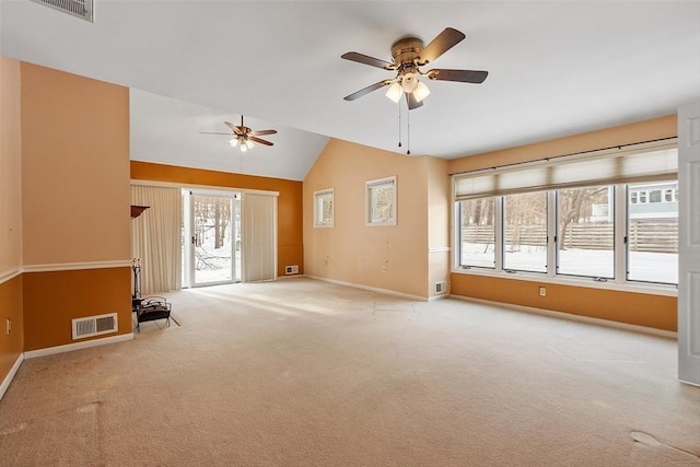 empty room with lofted ceiling, carpet, visible vents, and baseboards