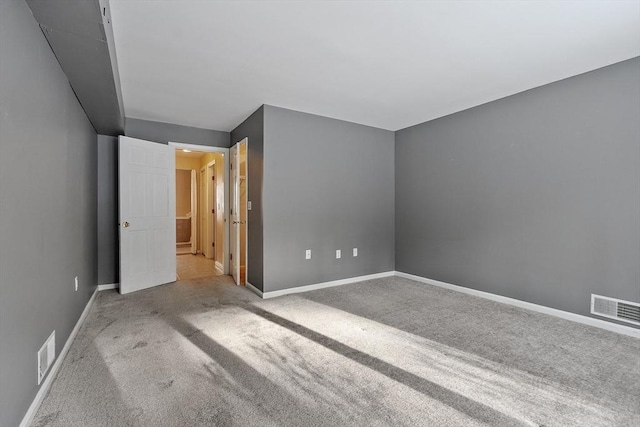 unfurnished bedroom with carpet floors, baseboards, and visible vents