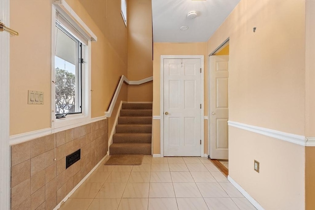 foyer entrance featuring stairway and light tile patterned floors