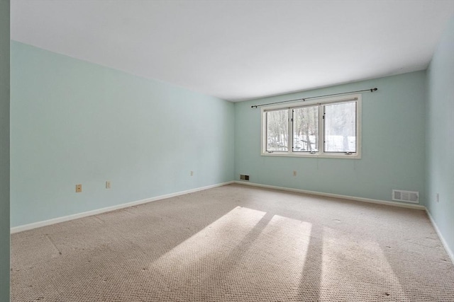 empty room featuring visible vents, light carpet, and baseboards