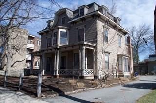 view of front of home with mansard roof and a porch