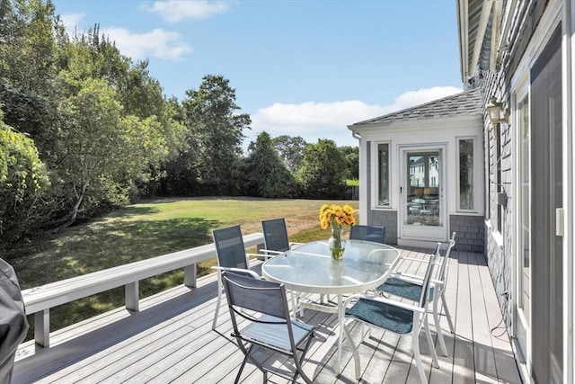 deck featuring a lawn and outdoor dining area