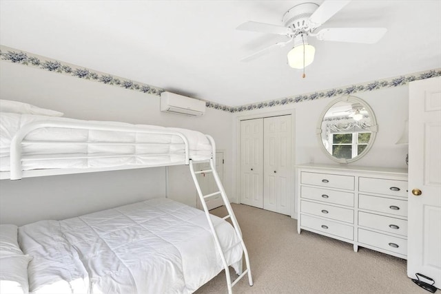 bedroom featuring a wall mounted air conditioner, a closet, a ceiling fan, and light colored carpet