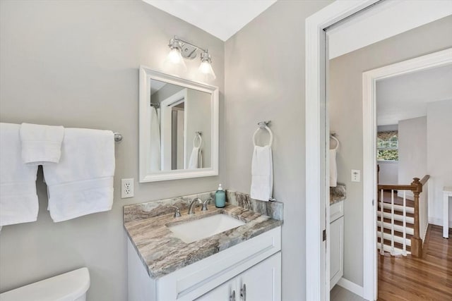 bathroom featuring toilet, wood finished floors, and vanity