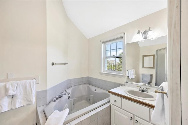 bathroom featuring a whirlpool tub, vanity, and vaulted ceiling