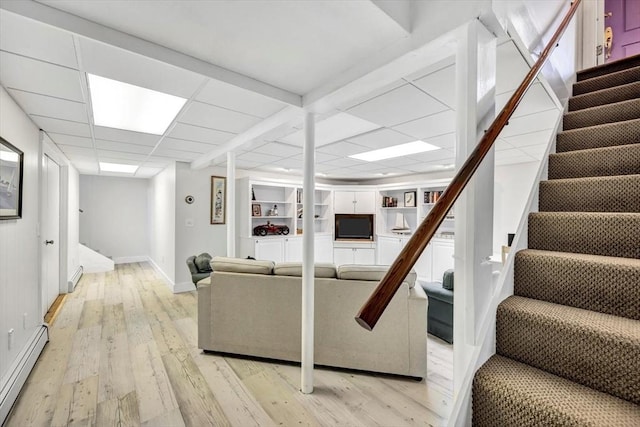 living area with baseboards, stairway, a baseboard heating unit, and light wood finished floors
