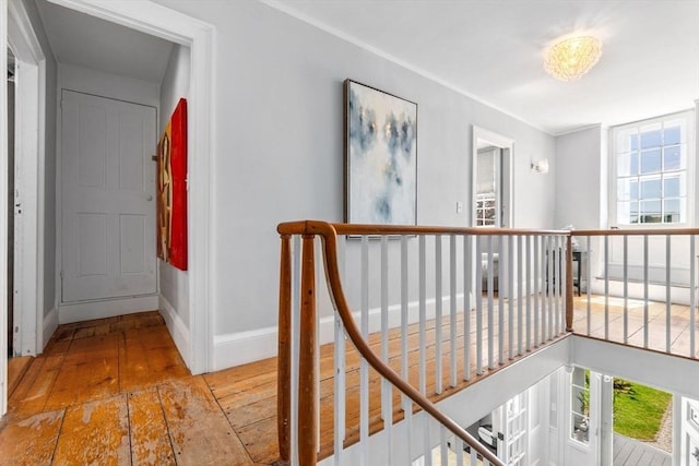 hall with plenty of natural light, an upstairs landing, and baseboards