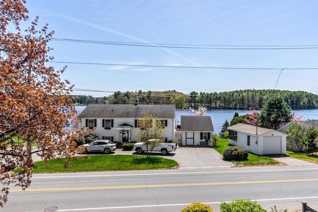 view of front of property with a water view, an outdoor structure, driveway, and a detached garage