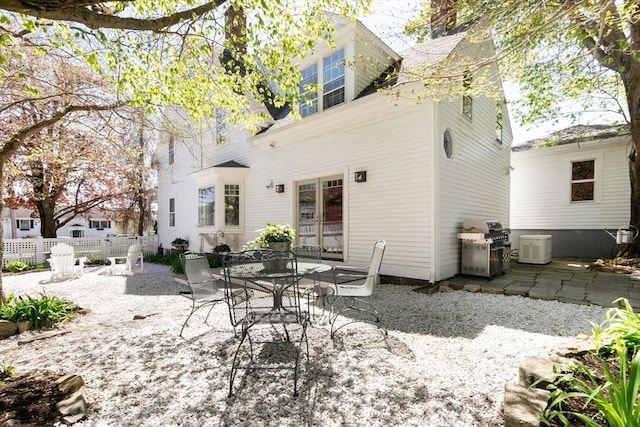 rear view of property with french doors, a patio, and fence