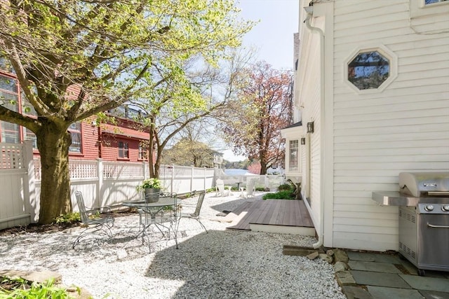 view of yard with a patio area, a wooden deck, and a fenced backyard