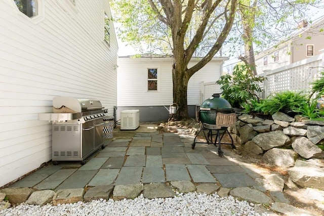 view of patio / terrace with fence and a grill