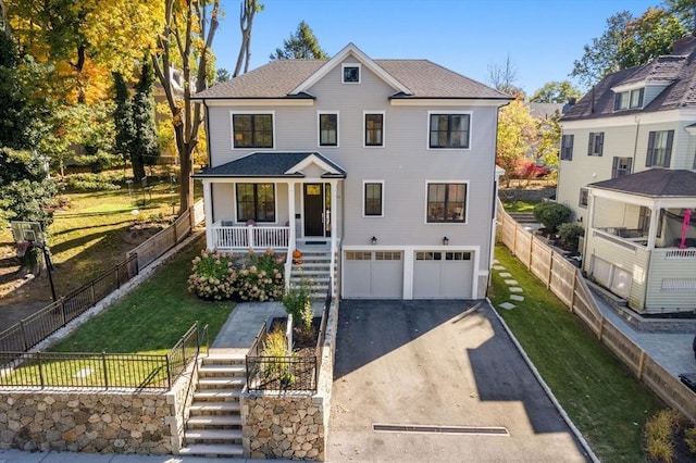 view of front of property featuring a porch, a garage, fence, driveway, and stairway