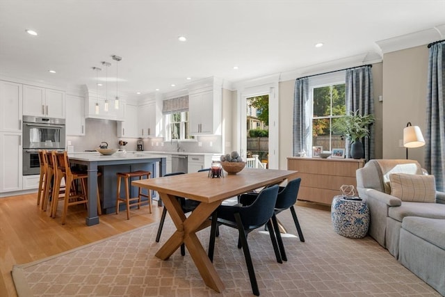 dining room featuring recessed lighting, light wood-type flooring, and crown molding