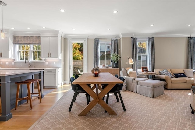 dining room featuring ornamental molding, recessed lighting, and light wood finished floors