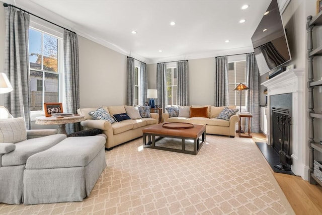 living room featuring a wealth of natural light, a fireplace with raised hearth, light wood finished floors, and recessed lighting